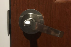 A lever-style doorknob with a turn-button lock, wherein the tiny slippery button must be turned to lock the door and change the vacancy indicator.