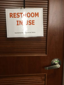 This door has both a laminated sign reading "restroom in use" and a doorknob indicator that says "vacant". No confusion there!